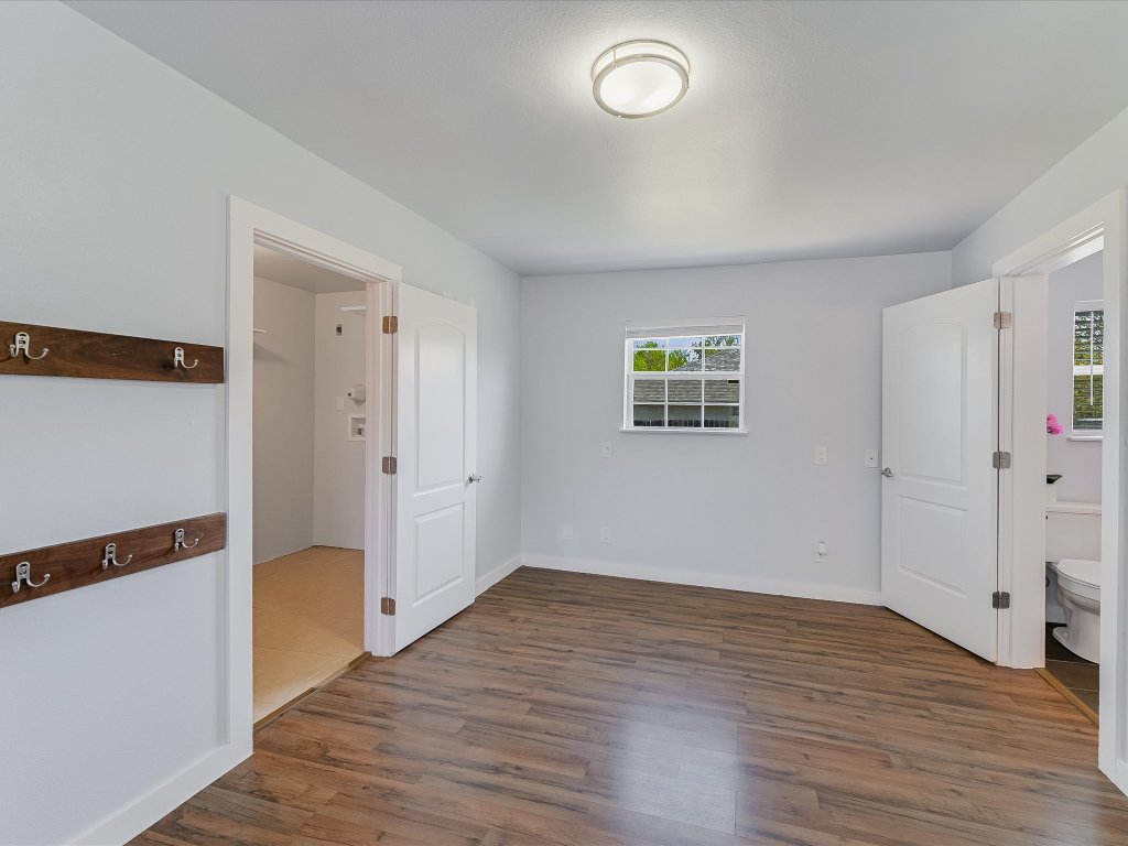 155 Travis Lane Spicewood, TX 78669 - Photo 6 of 33 an empty room with wooden floor and windows