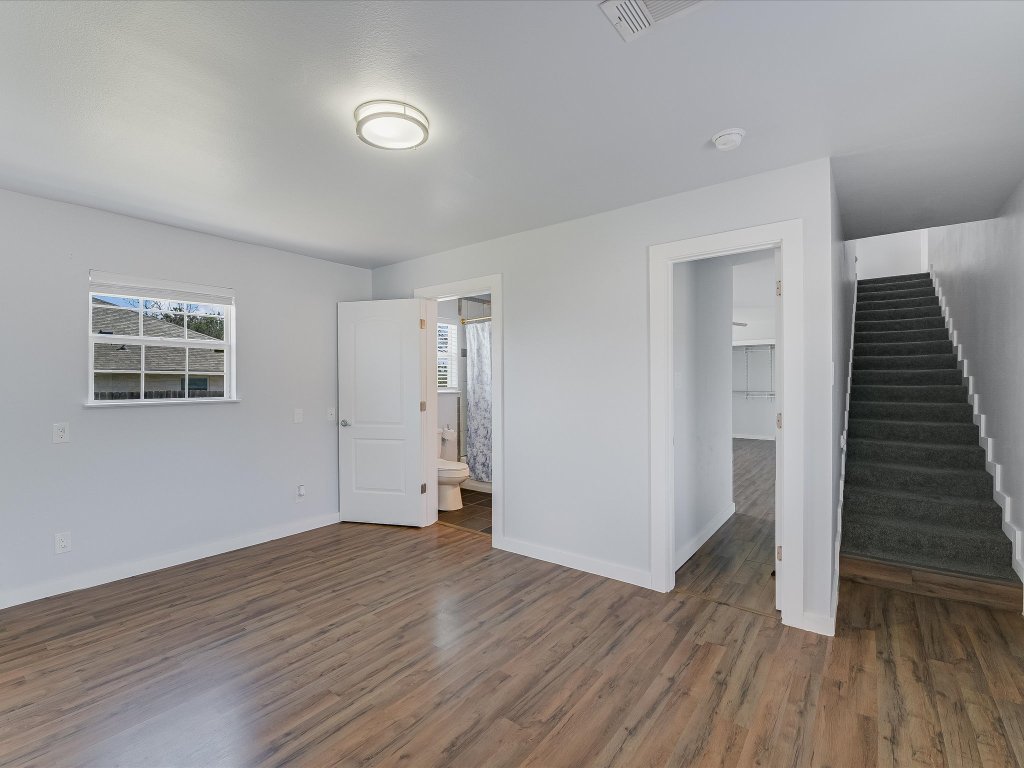 155 Travis Lane Spicewood, TX 78669 - Photo 7 of 33 a view of an empty room with wooden floor and stairs