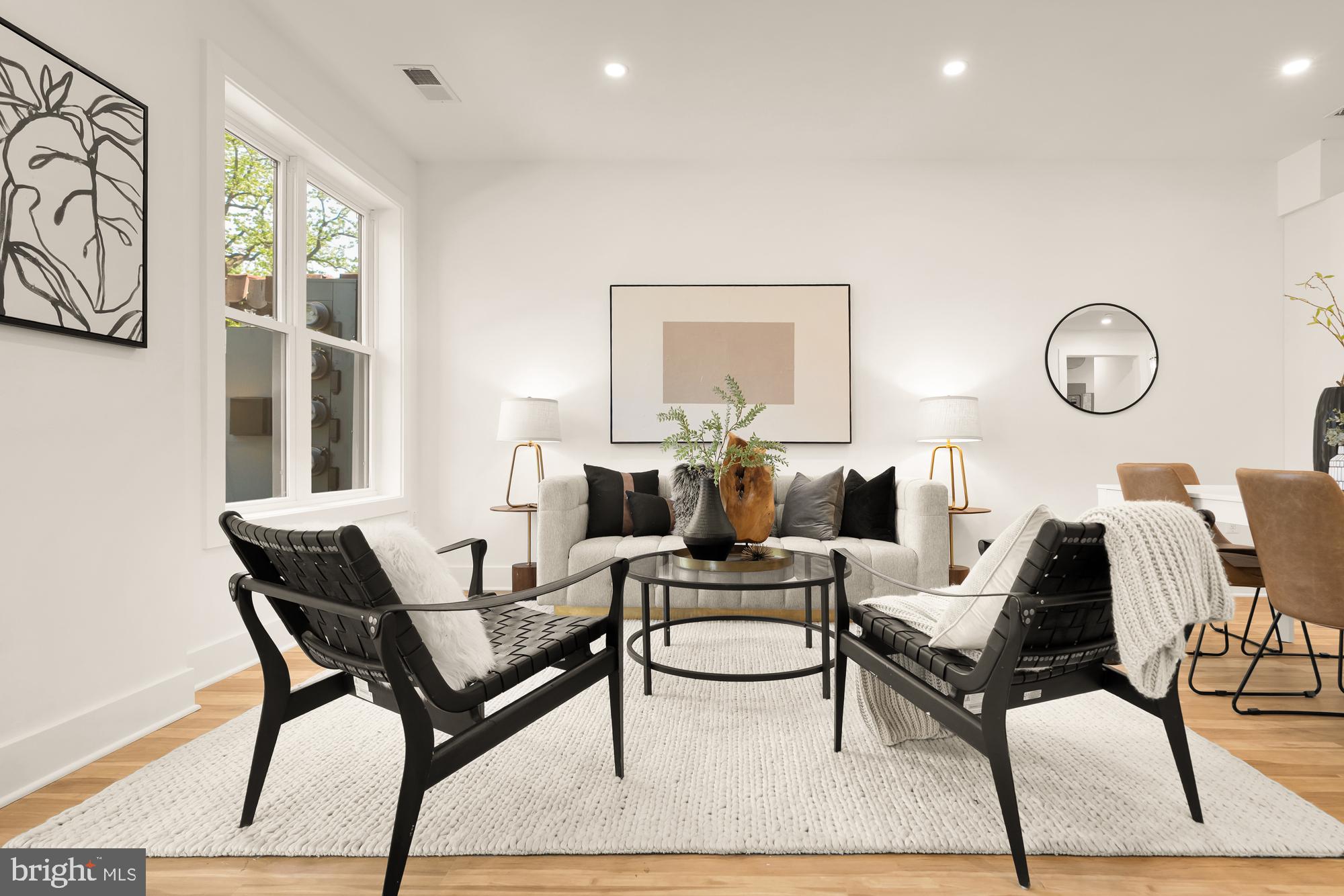 1251 Morse Street Northeast, Unit B Washington, DC 20002 - Photo 2 of 37 a living room with couches chairs and a large mirror with wooden floor