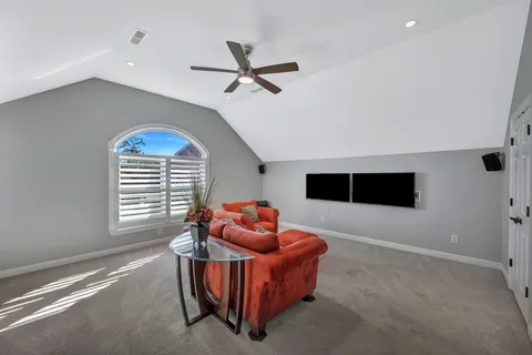a living room with furniture a ceiling fan and a window