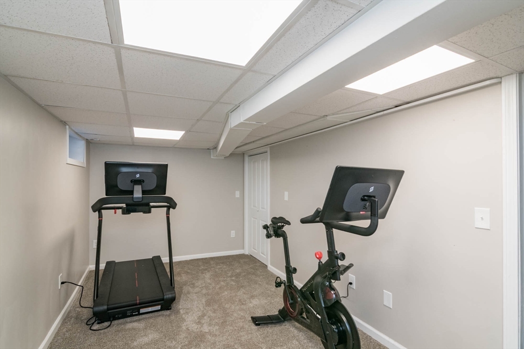 64 Ellendale Circle Springfield, MA 01128 - Photo 23 of 32 a room with gym equipment and a flat screen tv