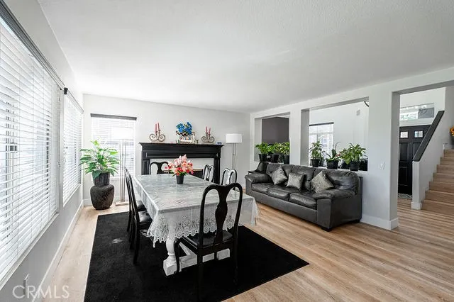 a kitchen with stainless steel appliances kitchen island granite countertop a refrigerator a stove a sink dishwasher and a dining table with wooden floor