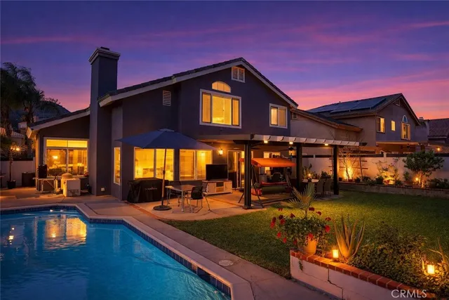 a view of a house with swimming pool next to a yard