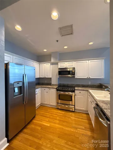 a kitchen with stainless steel appliances kitchen island granite countertop a stove a sink and a refrigerator