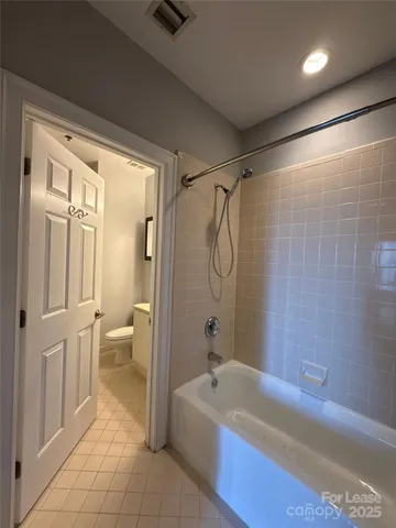 a bathroom with a granite countertop sink a toilet mirror and vanity