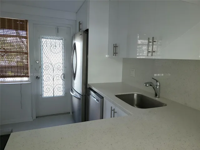 a kitchen with a sink and refrigerator