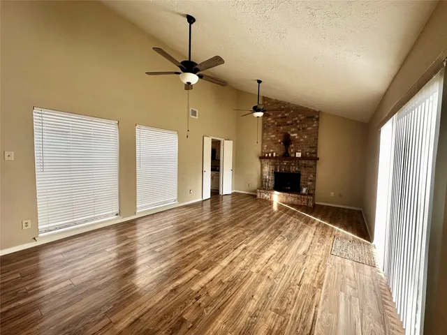 a view of an empty room with a window and a wooden floor