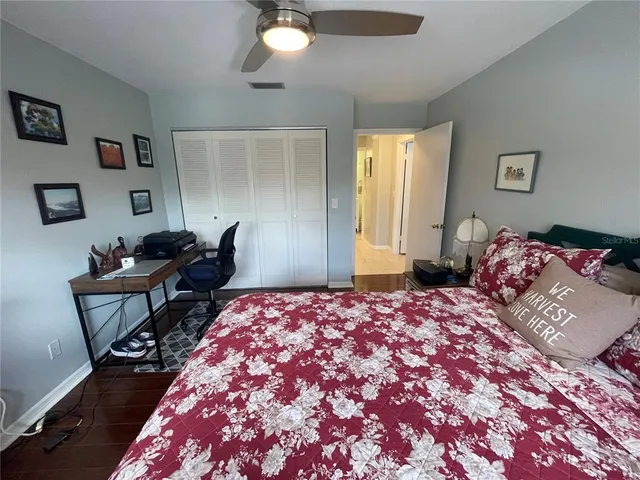 a spacious bedroom with a bed and wooden floor