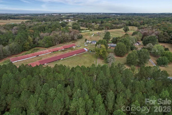 an aerial view of residential houses with outdoor space and trees