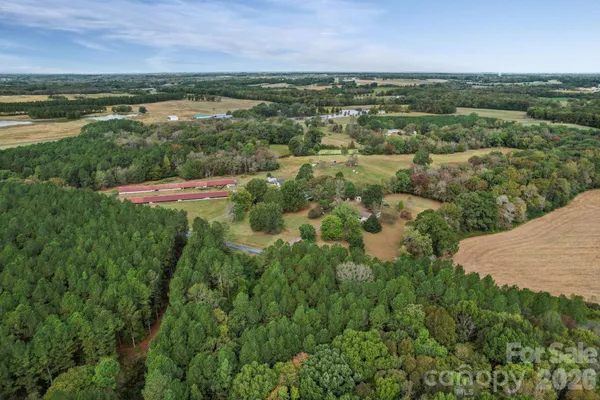 an aerial view of residential houses with outdoor space and trees