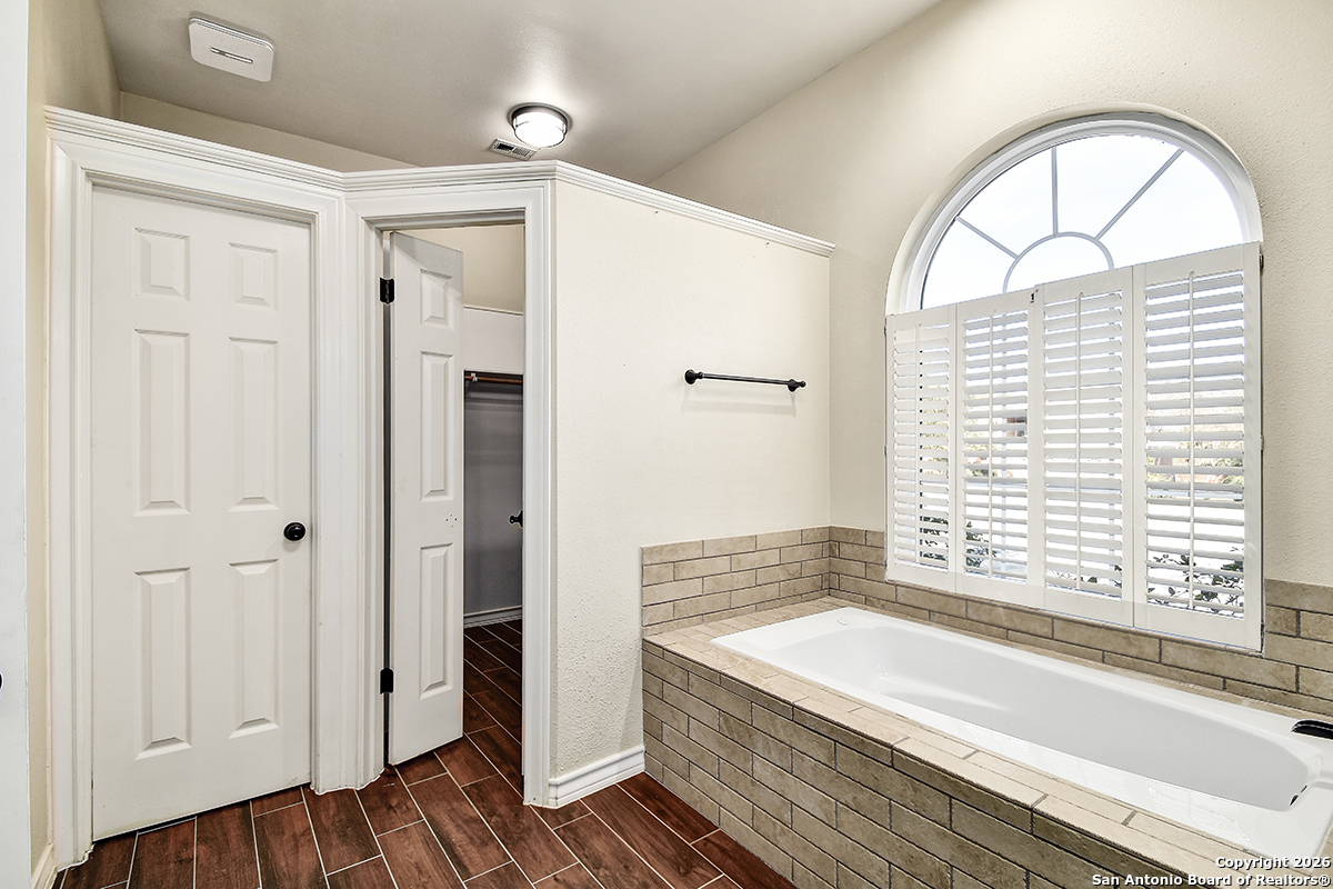 2642 Rim Oak San Antonio, TX 78232 - Photo 13 of 24 a bathroom with a large window a bathtub and shower