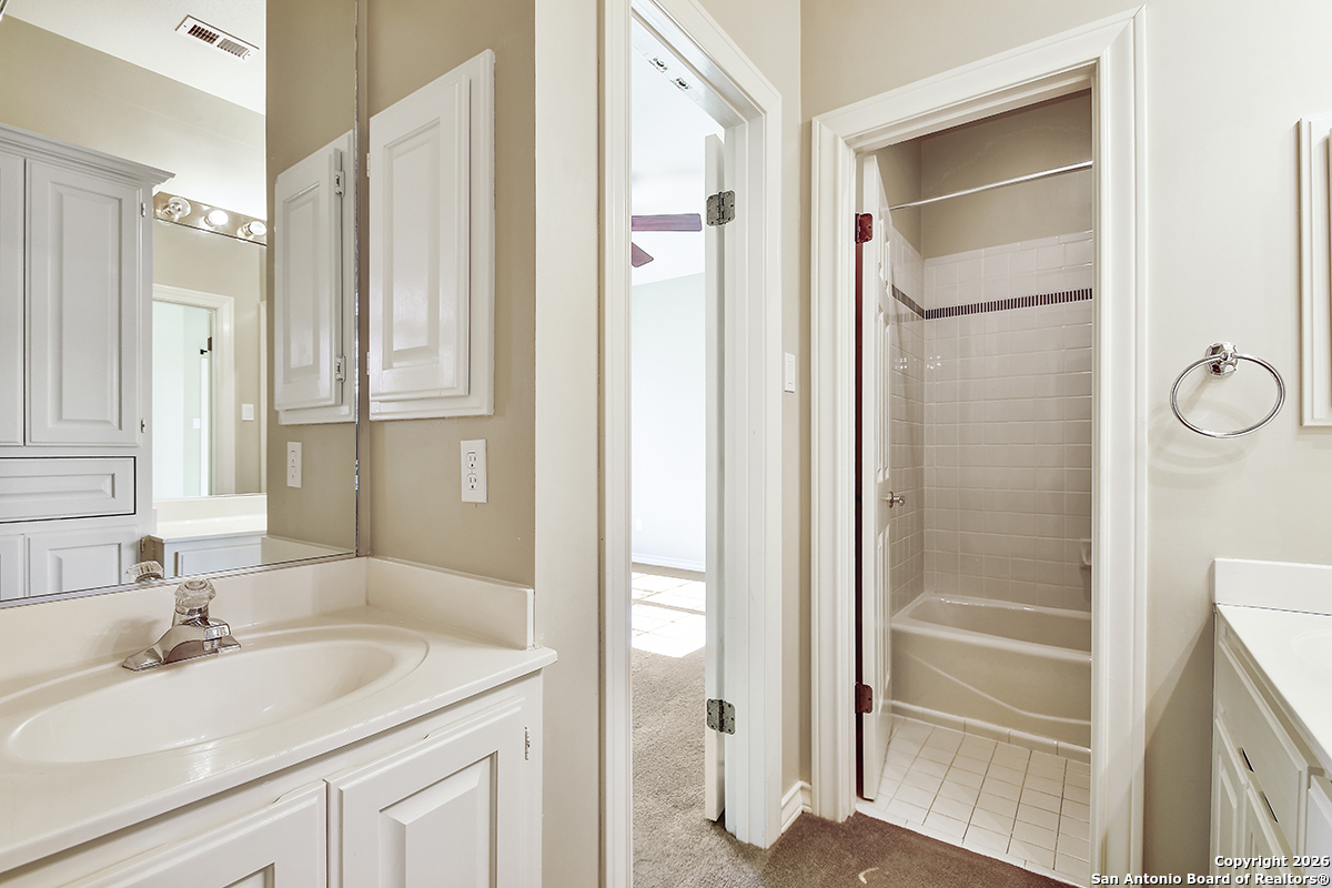 2642 Rim Oak San Antonio, TX 78232 - Photo 16 of 24 a bathroom with a granite countertop sink and a mirror