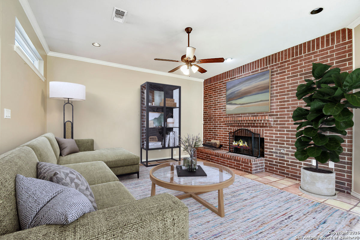 2642 Rim Oak San Antonio, TX 78232 - Photo 9 of 24 a living room with furniture a chandelier and a fireplace