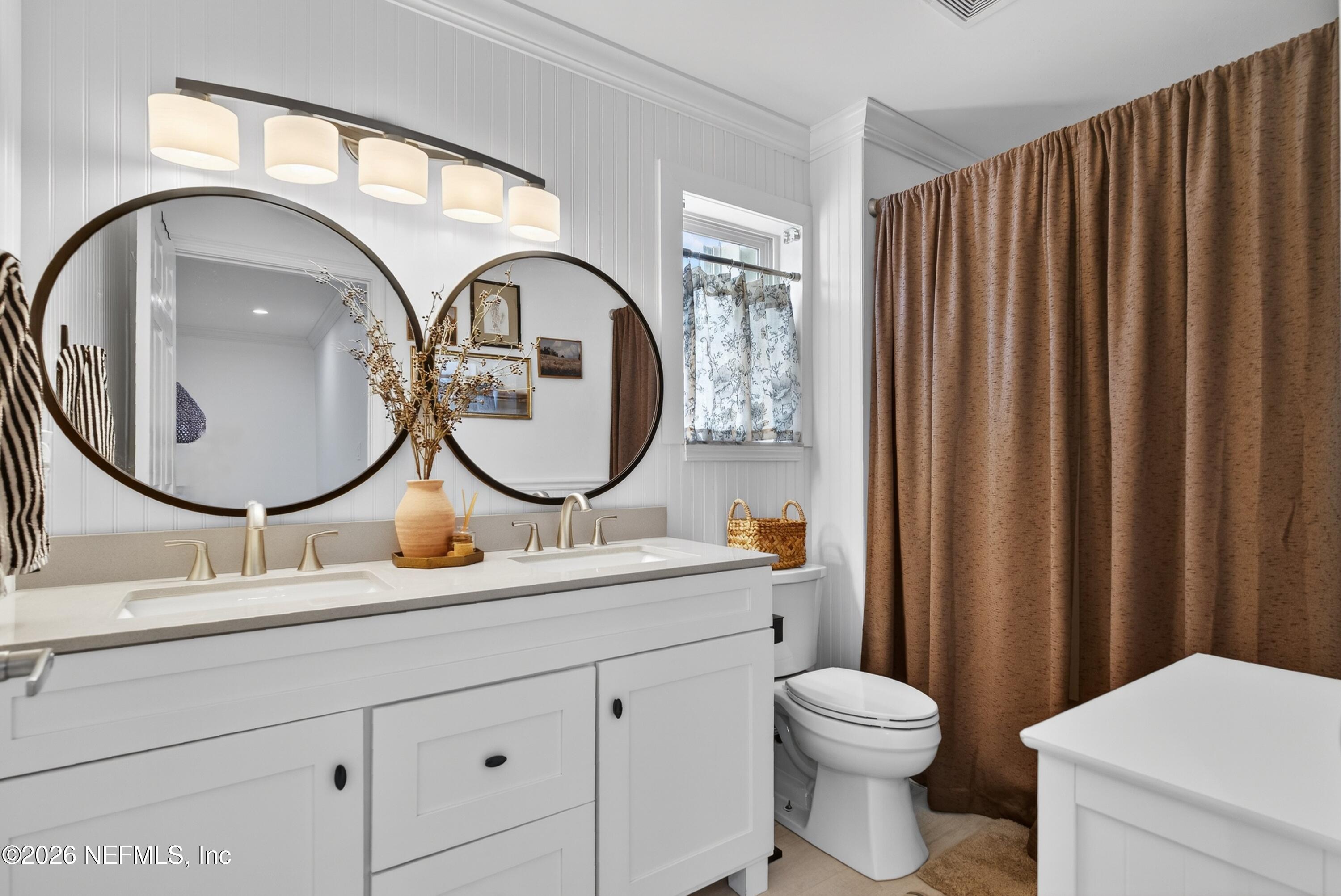 1110 Scheidel Court Atlantic Beach, FL 32233 - Photo 4 of 24 a bathroom with a toilet a sink and a mirror