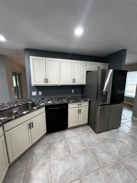 7854 Southwest 62nd Court Ocala, FL 34476 - Photo 10 of 18 a large kitchen with granite countertop a stove a sink dishwasher and a refrigerator