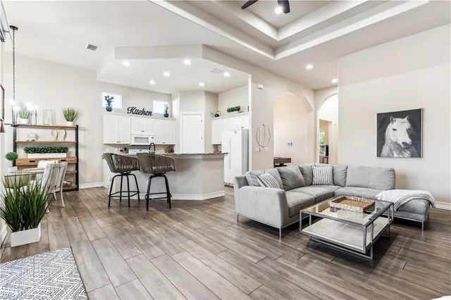 a living room with furniture and a wooden floor