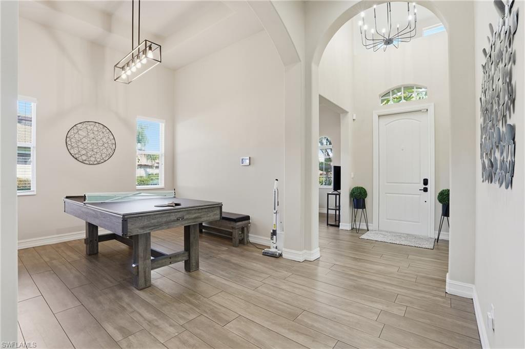 7821 Ashton Road Naples, FL 34113 - Photo 12 of 49 a room with wooden floor and a table
