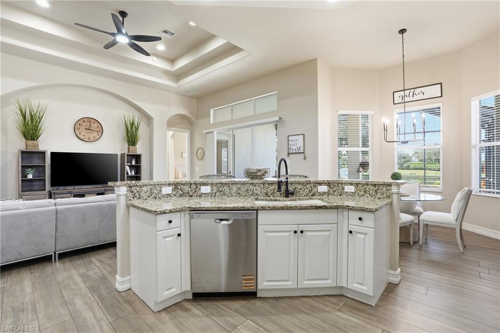 7821 Ashton Road Naples, FL 34113 - Photo 49 of 49 a kitchen with kitchen island granite countertop a sink cabinets and wooden floor