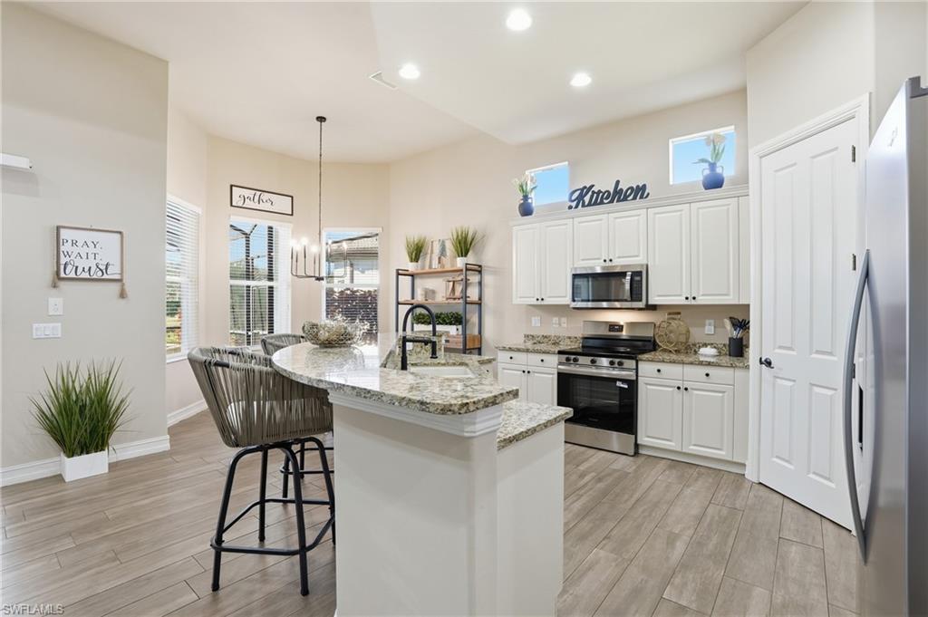 7821 Ashton Road Naples, FL 34113 - Photo 8 of 49 a kitchen with stainless steel appliances granite countertop a stove refrigerator and a sink