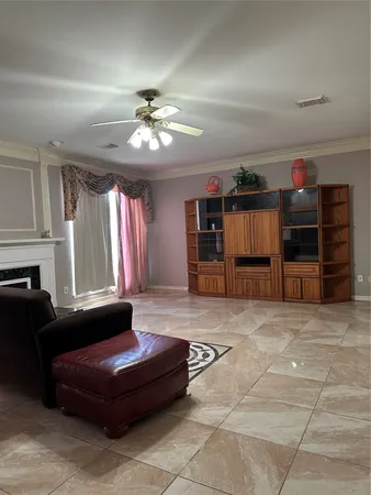a living room with furniture a ceiling fan and a window