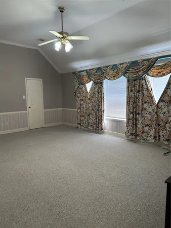 en empty room with windows and ceiling fan