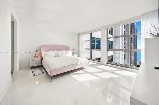 a bedroom with a bed painting and a large window