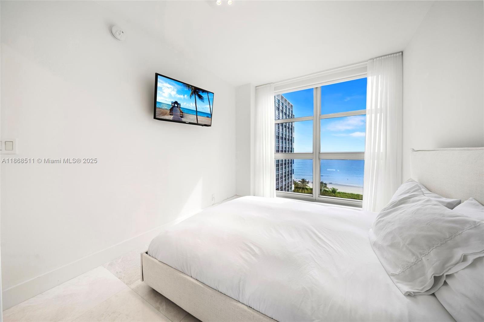 5055 Collins Avenue, Unit 10G Miami Beach, FL 33140 - Photo 13 of 20 a bedroom with a bed and a window