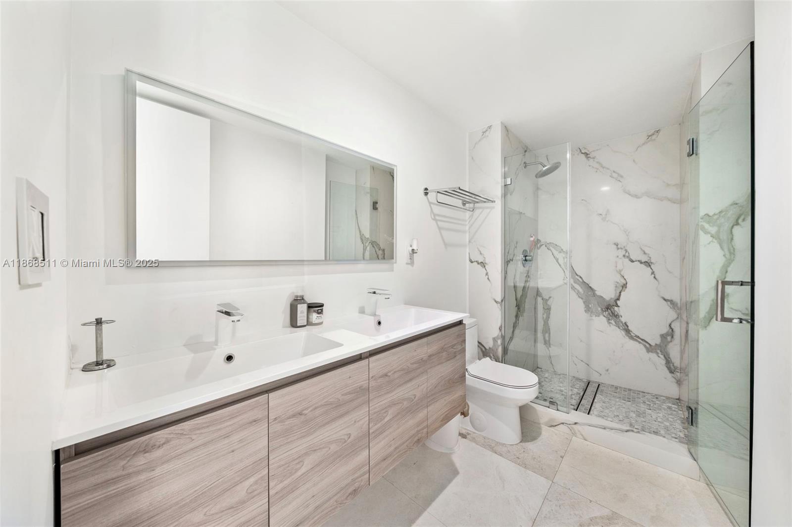 5055 Collins Avenue, Unit 10G Miami Beach, FL 33140 - Photo 15 of 20 a bathroom with a sink a toilet and shower