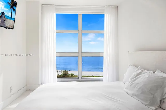 a view of a bedroom with a bed and a window