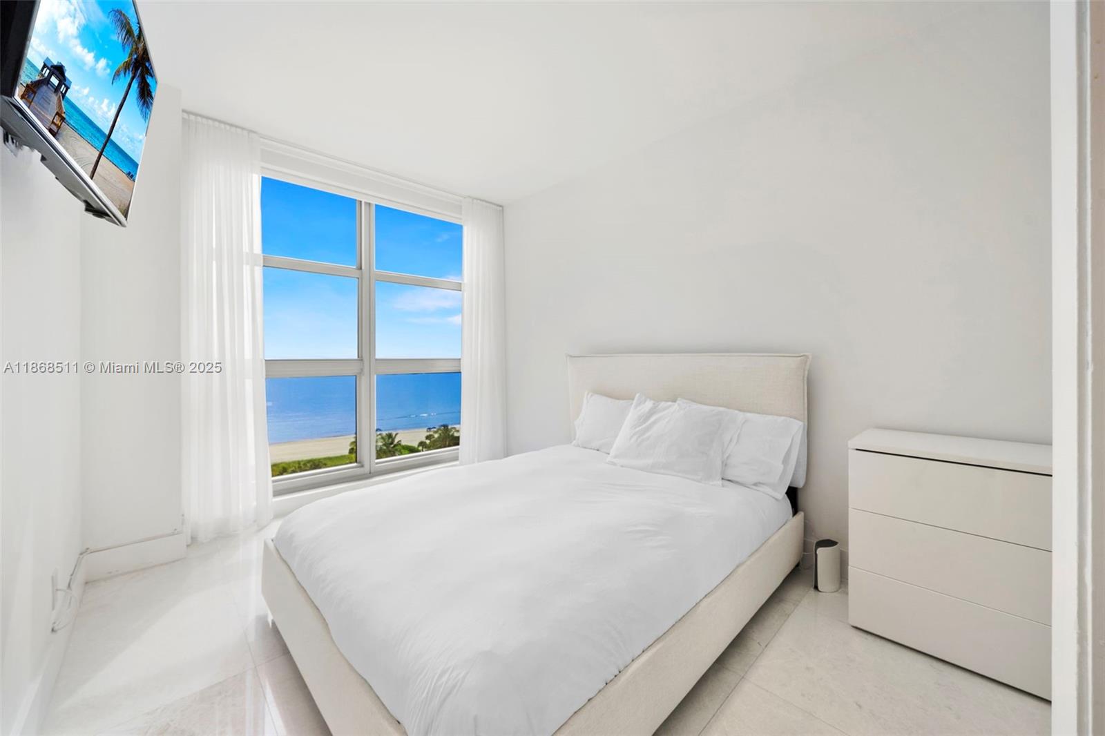 5055 Collins Avenue, Unit 10G Miami Beach, FL 33140 - Photo 17 of 20 a bedroom with a bed and a window