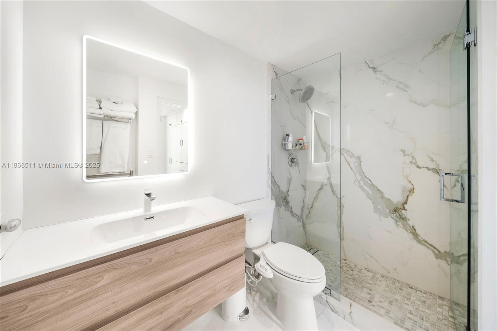 5055 Collins Avenue, Unit 10G Miami Beach, FL 33140 - Photo 18 of 20 a bathroom with a sink a toilet and shower