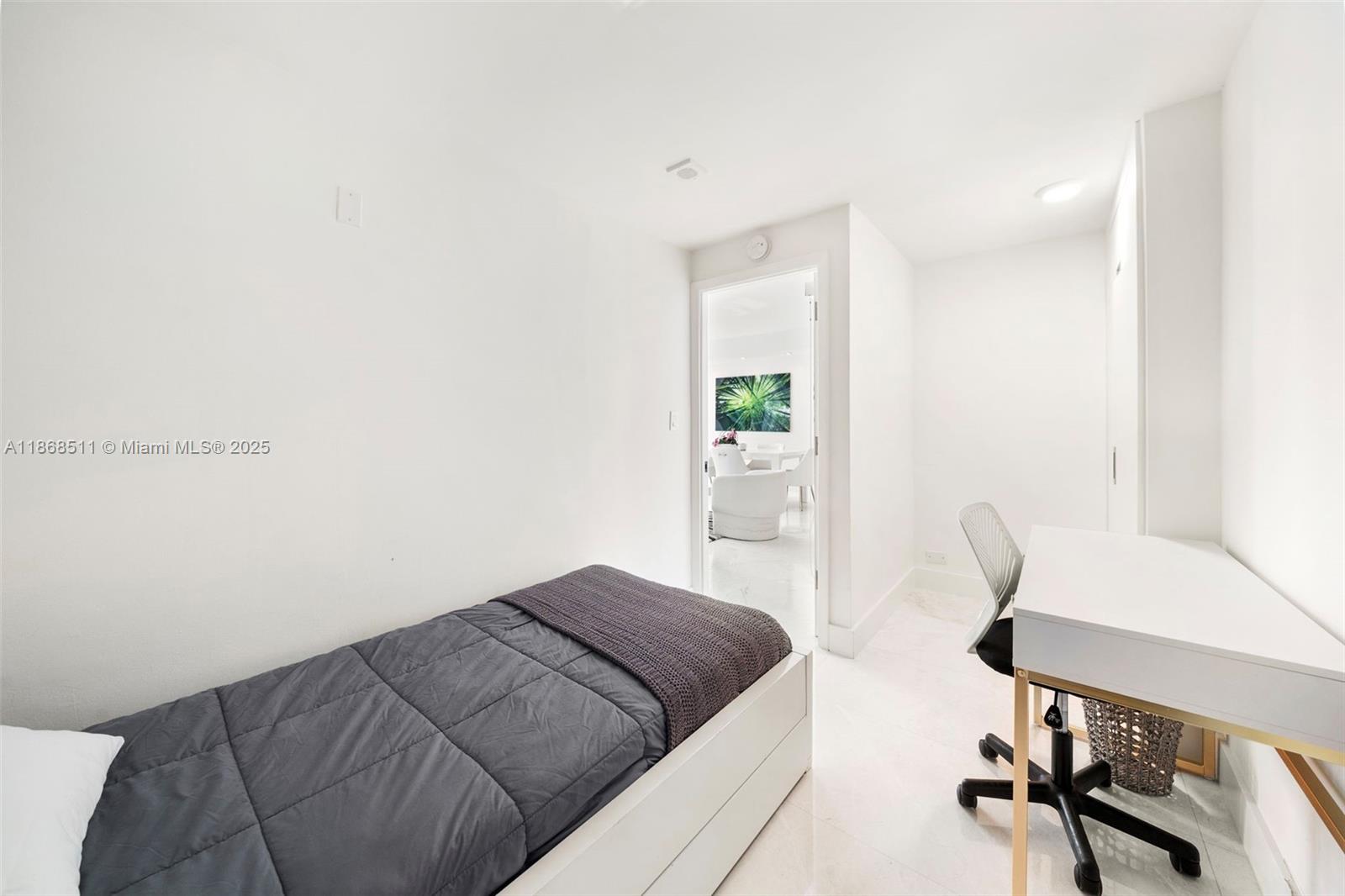 5055 Collins Avenue, Unit 10G Miami Beach, FL 33140 - Photo 19 of 20 a bedroom with a bed and a desk