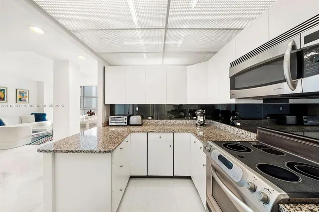 a kitchen with stainless steel appliances granite countertop a sink and a stove