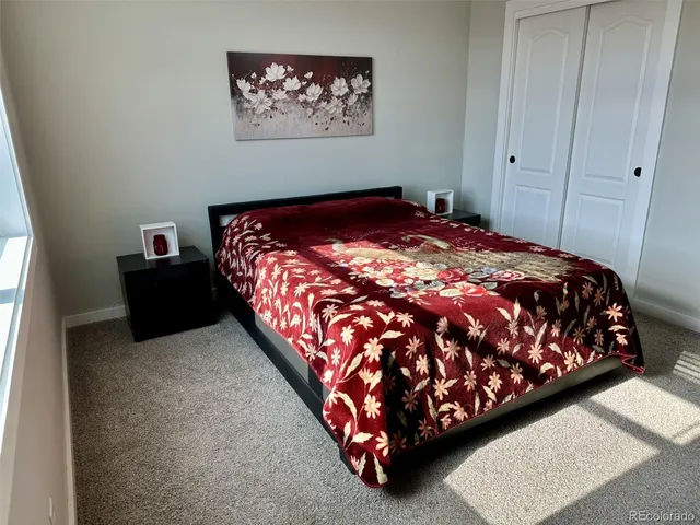 a bedroom with a bed and painting on the wall