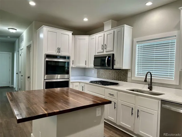 a kitchen with stainless steel appliances kitchen island granite countertop a sink dishwasher stove and oven