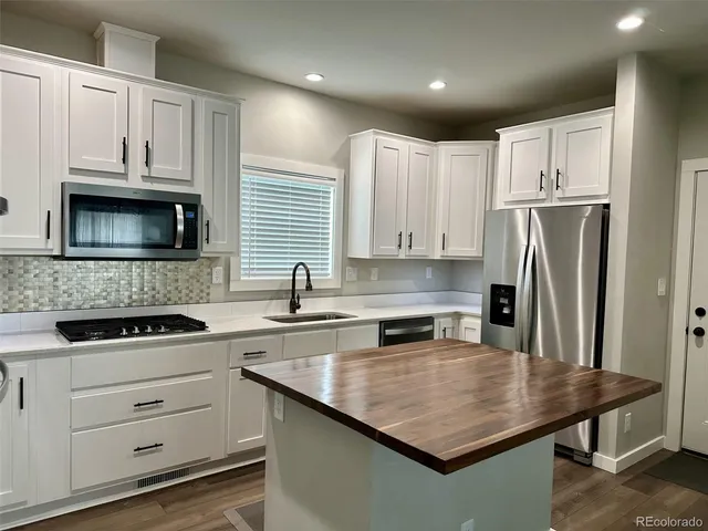 a kitchen with white cabinets stainless steel appliances and sink