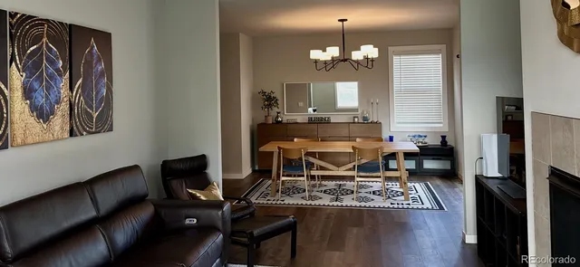 a living room with furniture a fireplace and a chandelier