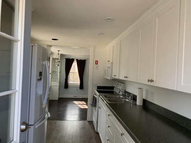 a kitchen with stainless steel appliances a stove a sink and white cabinets