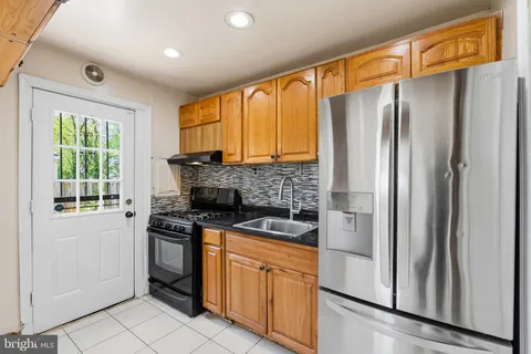 a kitchen with stainless steel appliances granite countertop a refrigerator and a stove top oven
