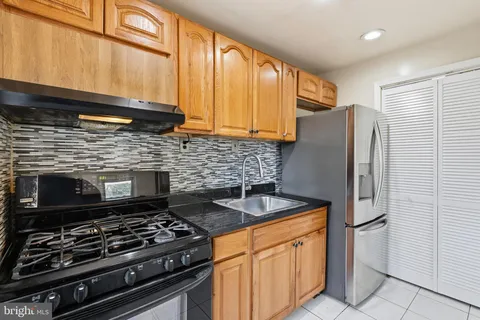 a kitchen with stainless steel appliances granite countertop a stove a refrigerator and a microwave