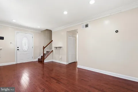a view of an empty room with wooden floor