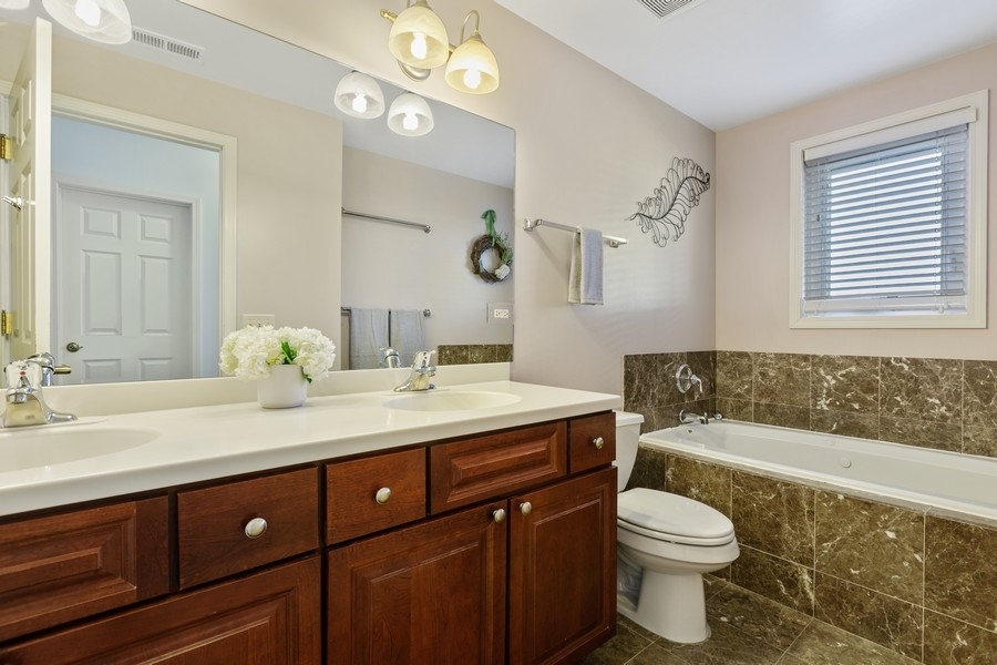 26 East 14th Place, Unit 15W Chicago, IL 60605 - Photo 28 of 36 a spacious bathroom with a granite countertop toilet sink and mirror