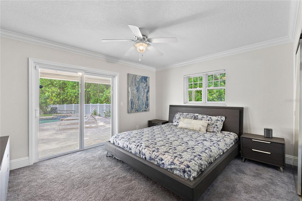 3663 Berger Road Lutz, FL 33548 - Photo 26 of 65 a bedroom with a bed a table and a large window