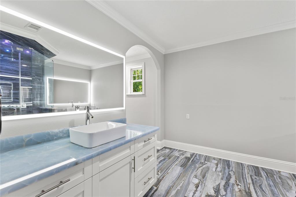 3663 Berger Road Lutz, FL 33548 - Photo 36 of 65 a spacious bathroom with a granite countertop sink and a mirror