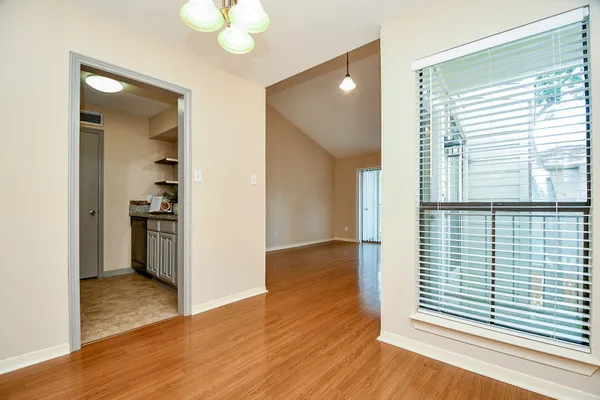 a view of empty room with wooden floor and fireplace
