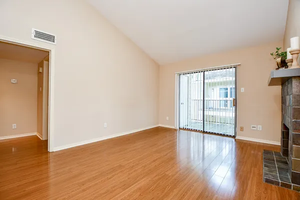 a view of an empty room with wooden floor