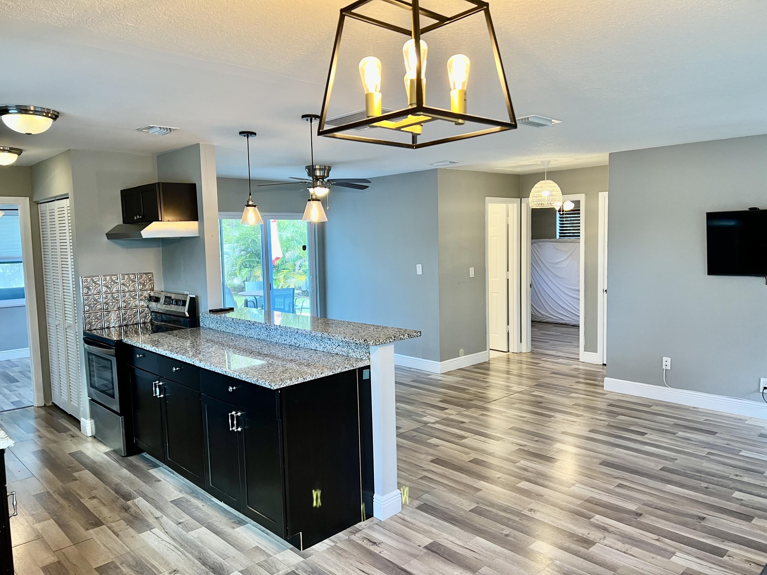 511 Northwest 3rd Street Delray Beach, FL 33444 - Photo 8 of 21 a kitchen with stainless steel appliances granite countertop a kitchen island a stove and a sink