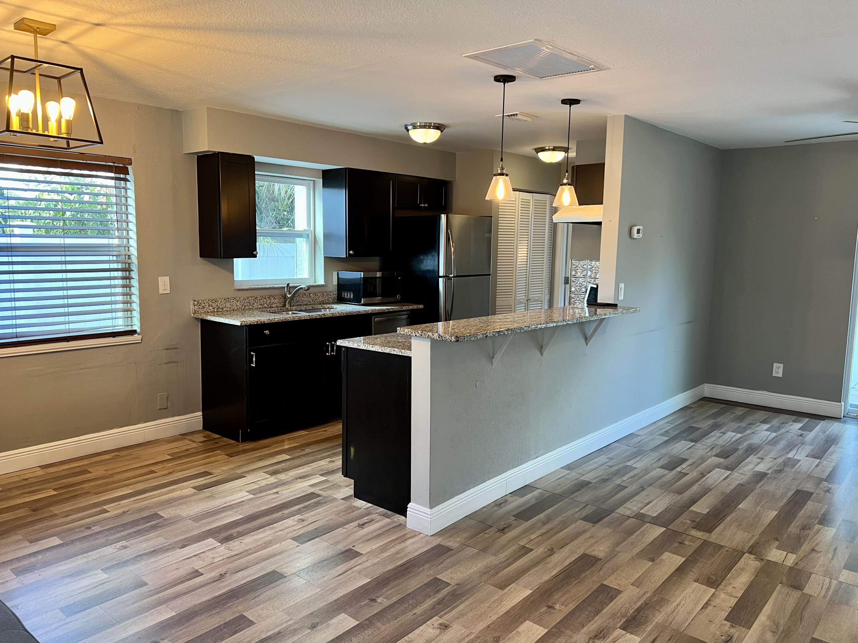 511 Northwest 3rd Street Delray Beach, FL 33444 - Photo 9 of 21 a kitchen with kitchen island granite countertop wooden cabinets and granite counter tops