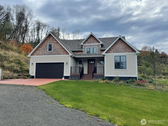 a front view of a house with a garden and yard