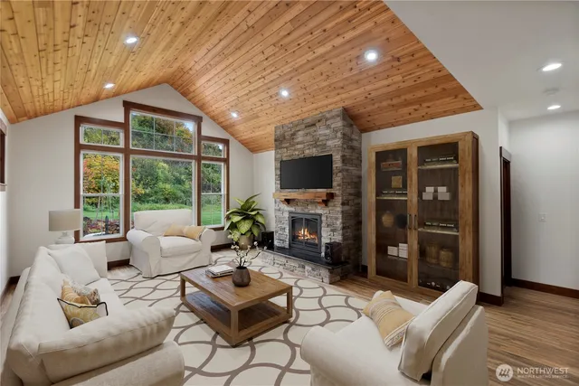 a living room with furniture a flat screen tv and a floor to ceiling window